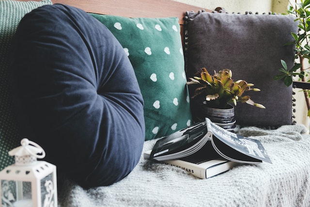 a couch with throw pillows and two books on it